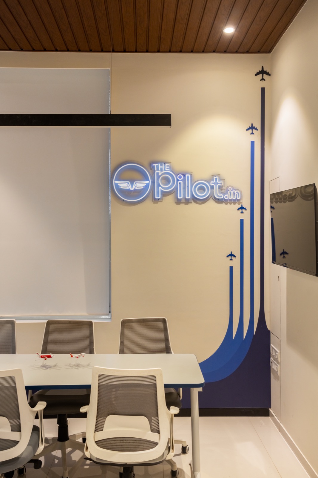 Briefing room with ThePilot.in neon signage, planning table and student seating