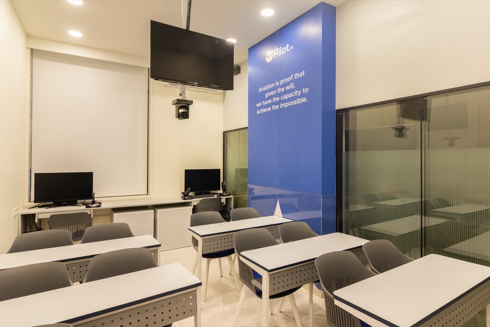 ThePilot.in lecture room with ceiling-mounted screens and an aviation quote wall