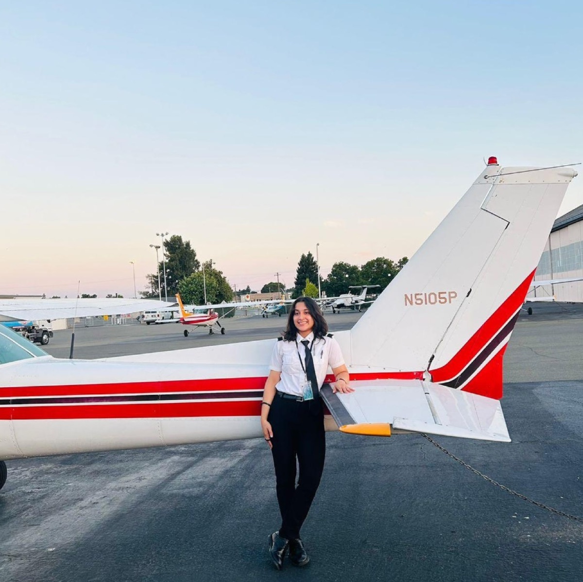 ThePilot.in student pilot in uniform beside a Cessna N5105P trainer at an FTO apron